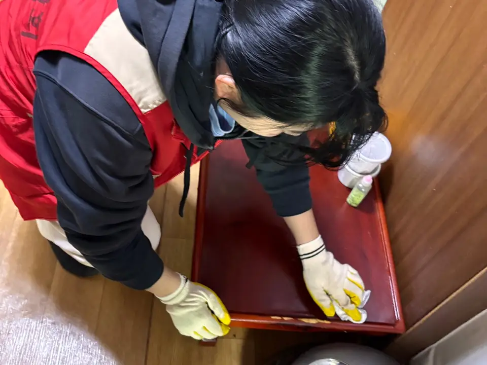 어르신 댁 가구를 닦는 봉사자